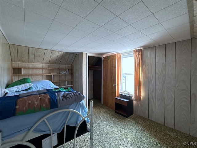 bedroom with wood walls and carpet floors