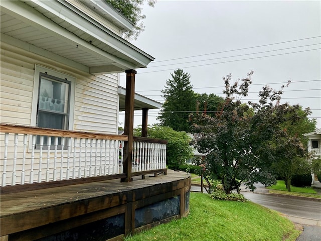 wooden terrace featuring a lawn