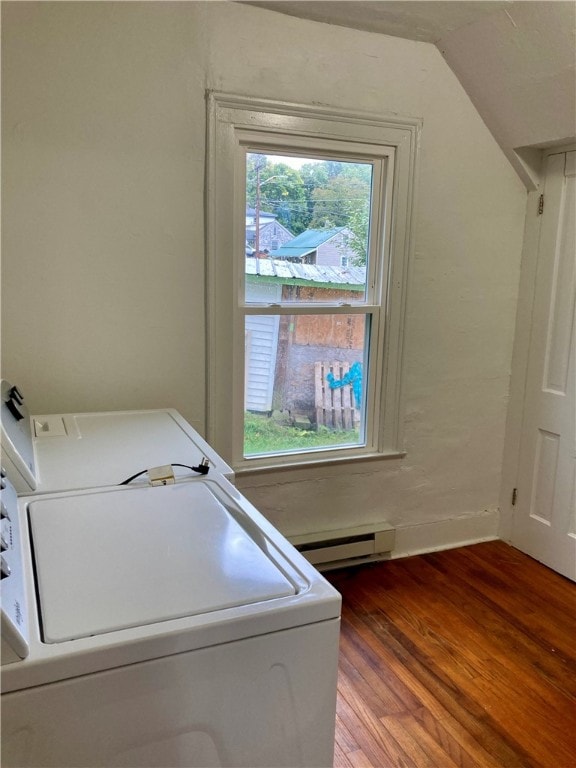 clothes washing area with hardwood / wood-style flooring, a baseboard radiator, and washer and dryer