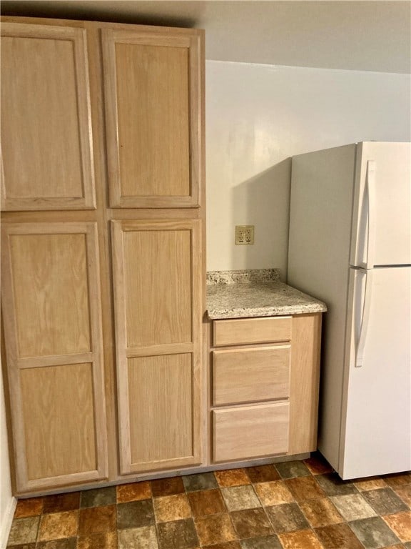 kitchen featuring light brown cabinets and white refrigerator