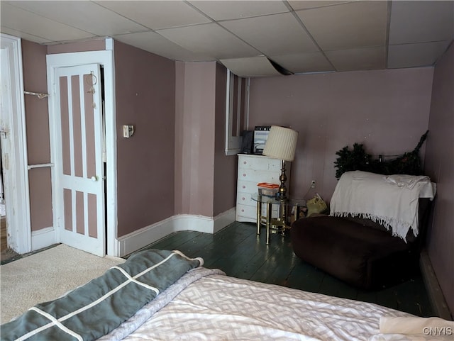 bedroom featuring a drop ceiling and dark hardwood / wood-style floors