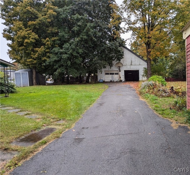 view of front of house with a storage unit and a front yard