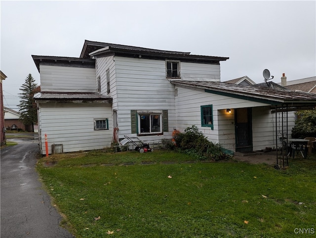 rear view of property with a lawn