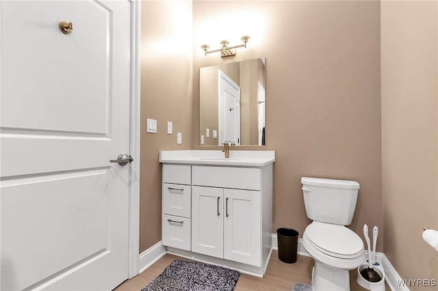 bathroom with hardwood / wood-style floors, vanity, and toilet