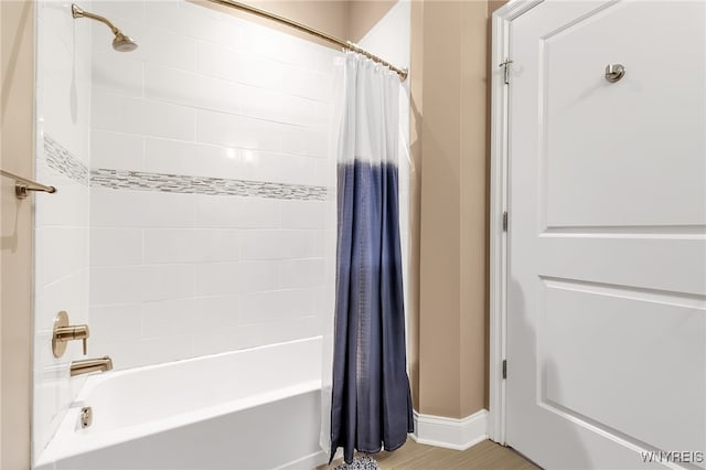 bathroom with hardwood / wood-style flooring and shower / bath combo with shower curtain