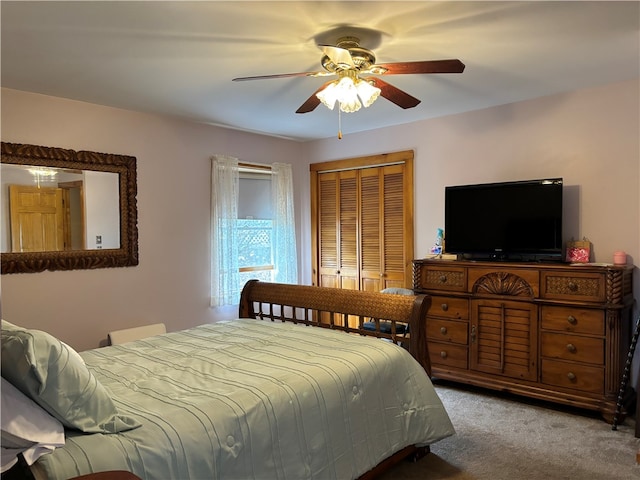 carpeted bedroom featuring ceiling fan and a closet