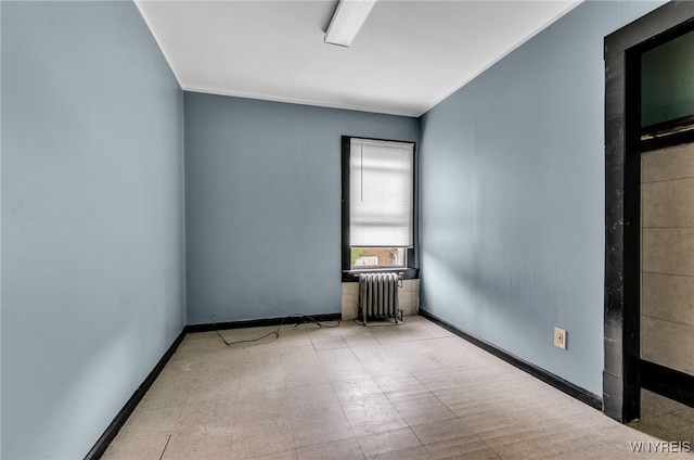 empty room featuring crown molding and radiator heating unit