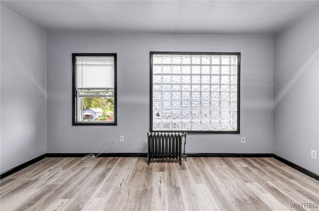 unfurnished room with radiator and light hardwood / wood-style floors