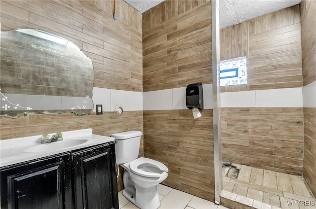 bathroom featuring vanity, tile walls, toilet, and tile patterned floors