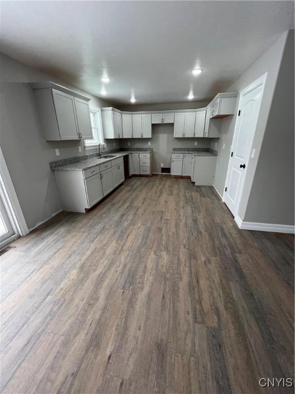 kitchen with stone counters, sink, and dark hardwood / wood-style floors