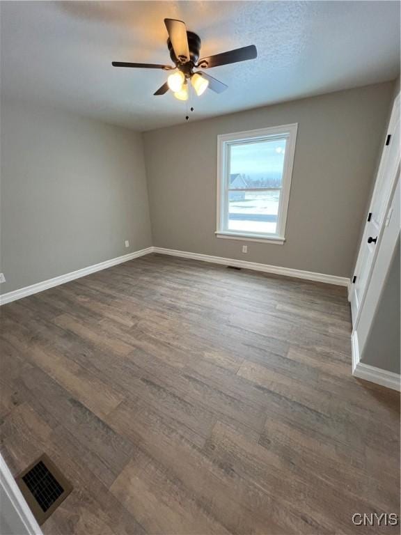 unfurnished room with dark hardwood / wood-style floors and ceiling fan