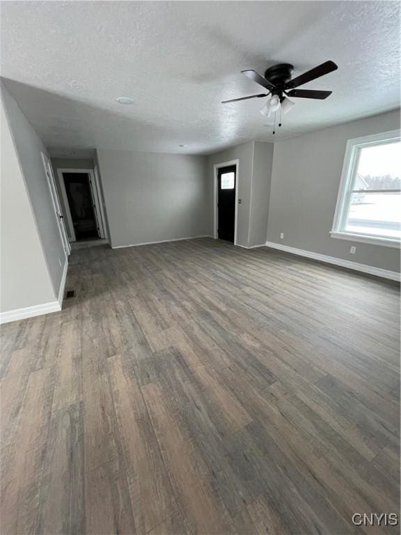 spare room featuring a textured ceiling, ceiling fan, and dark hardwood / wood-style floors