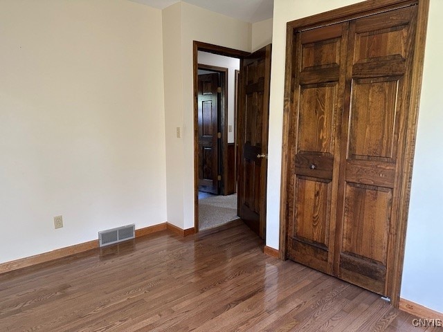 unfurnished bedroom featuring dark hardwood / wood-style flooring