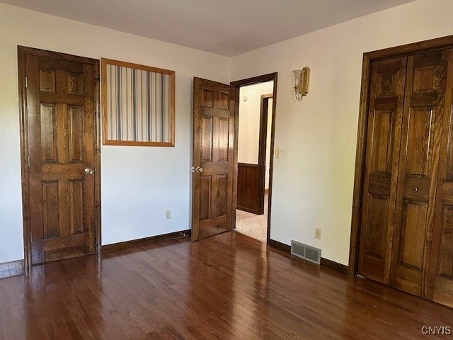 unfurnished bedroom with dark hardwood / wood-style flooring