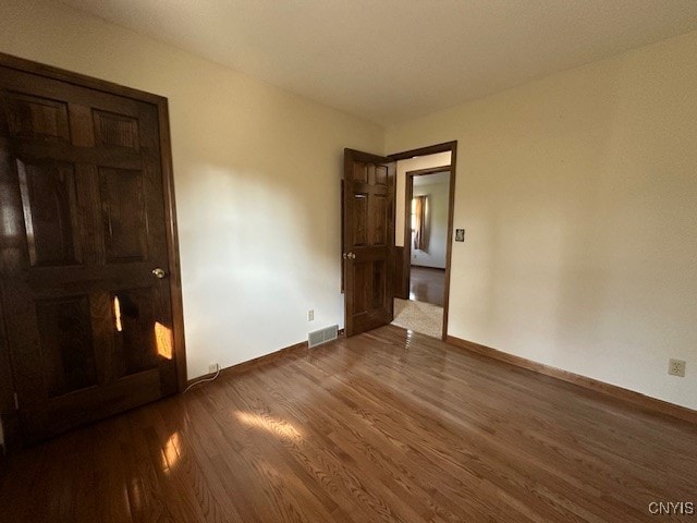 unfurnished bedroom with dark hardwood / wood-style floors