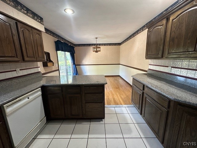 kitchen featuring pendant lighting, white dishwasher, light tile patterned flooring, kitchen peninsula, and dark brown cabinets