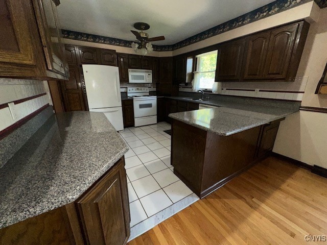 kitchen with light wood-type flooring, white appliances, ceiling fan, and dark brown cabinetry