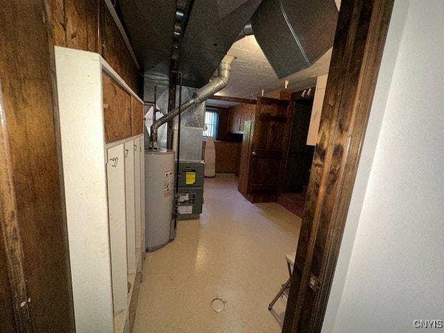 basement with water heater and wood walls