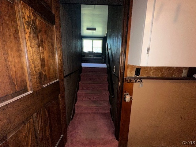 hallway with dark colored carpet