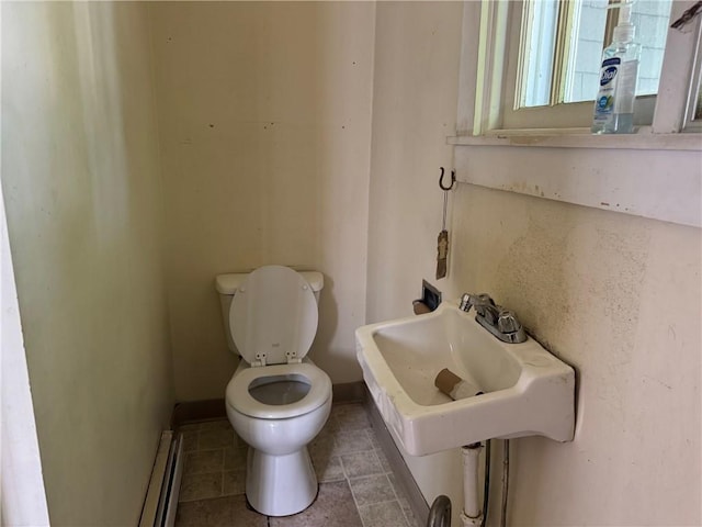 14 Wells St, Hornell, NY 14843 - bathroom featuring toilet, a baseboard heating unit, a sink, baseboards, and tile patterned floors