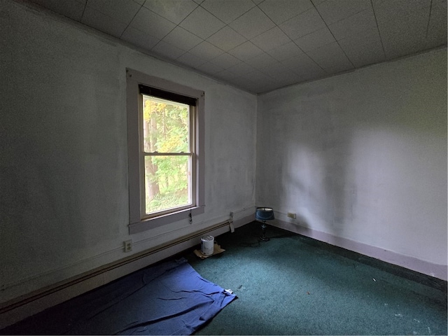 carpeted empty room featuring a paneled ceiling