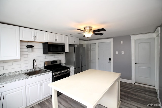 kitchen with ceiling fan, sink, white cabinetry, appliances with stainless steel finishes, and dark hardwood / wood-style floors