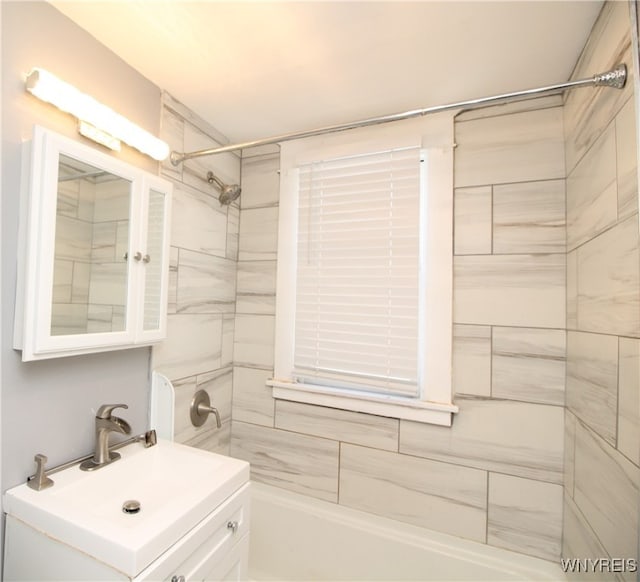 bathroom with tiled shower / bath and vanity