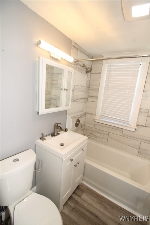 full bathroom with tiled shower / bath, vanity, toilet, and hardwood / wood-style flooring