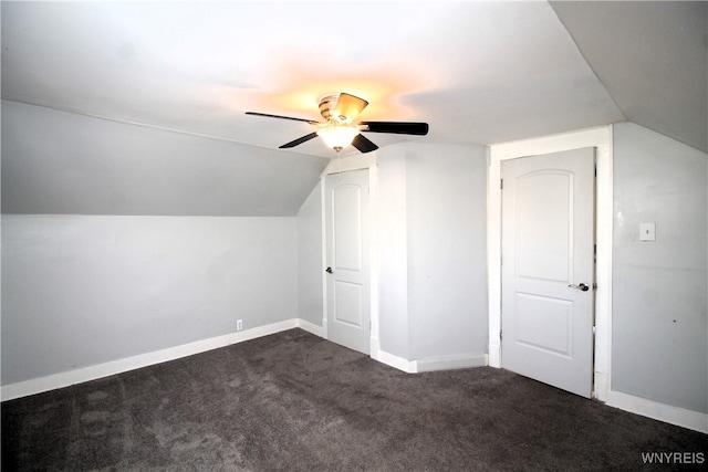 additional living space featuring dark carpet, vaulted ceiling, and ceiling fan