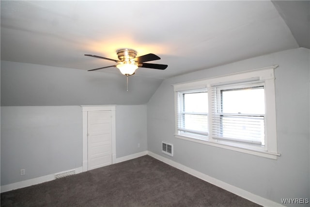 bonus room with dark carpet, vaulted ceiling, and ceiling fan