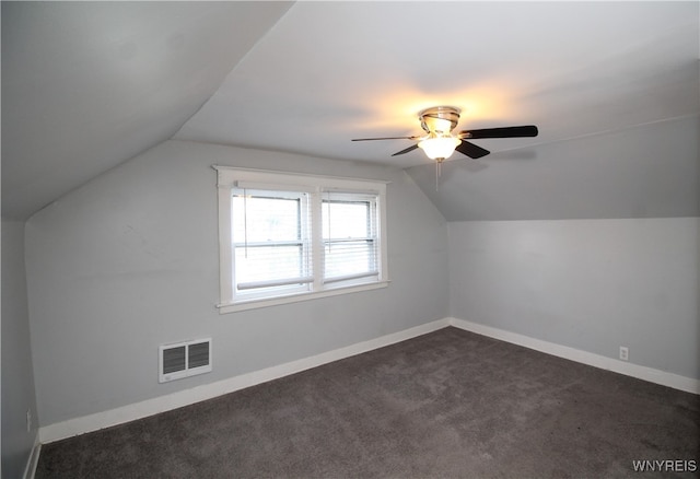 bonus room with vaulted ceiling, dark colored carpet, and ceiling fan