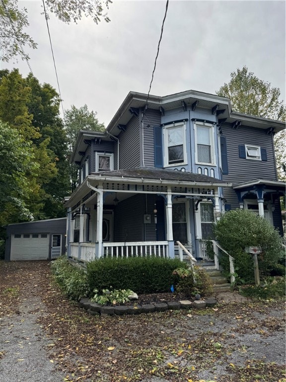 italianate home with covered porch, an outdoor structure, and a garage