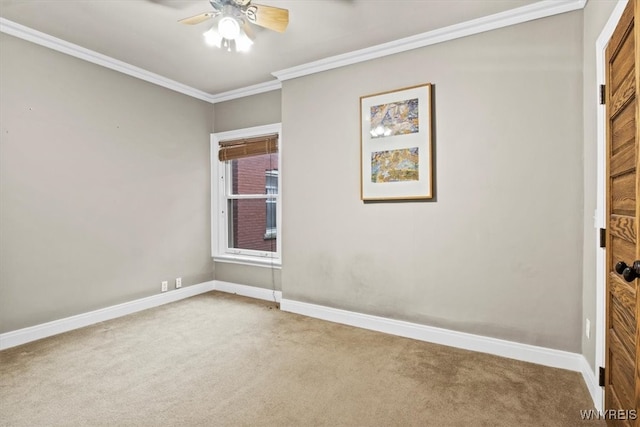 empty room featuring carpet floors, crown molding, and ceiling fan