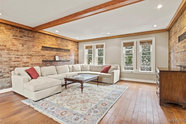 living room with beamed ceiling, light wood-type flooring, and crown molding