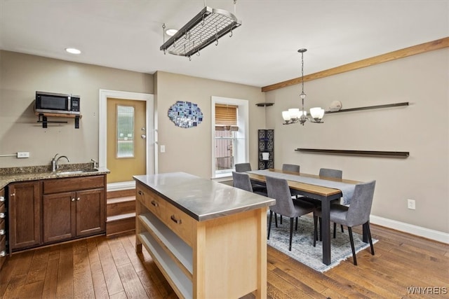 kitchen featuring an inviting chandelier, dark hardwood / wood-style floors, plenty of natural light, and stainless steel counters