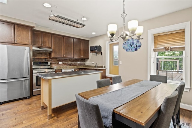 dining space with a notable chandelier and light hardwood / wood-style floors