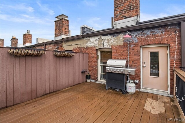 wooden terrace featuring a grill