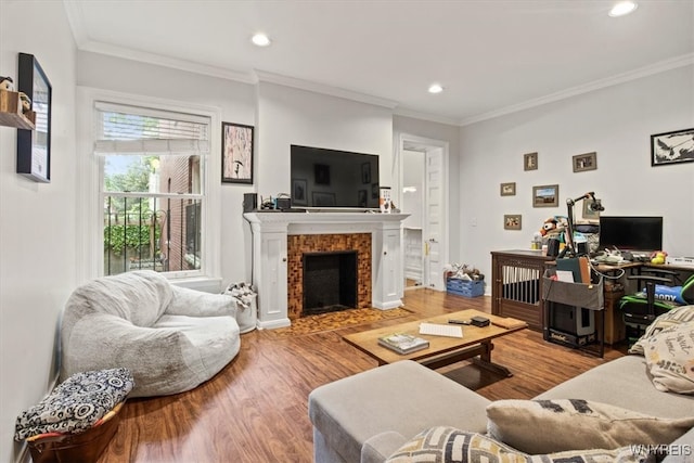 living room featuring a fireplace, ornamental molding, and hardwood / wood-style flooring