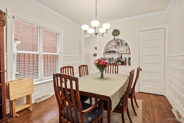 dining room featuring a notable chandelier, built in features, dark hardwood / wood-style floors, and crown molding