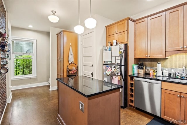 kitchen with sink, decorative light fixtures, appliances with stainless steel finishes, a center island, and decorative backsplash