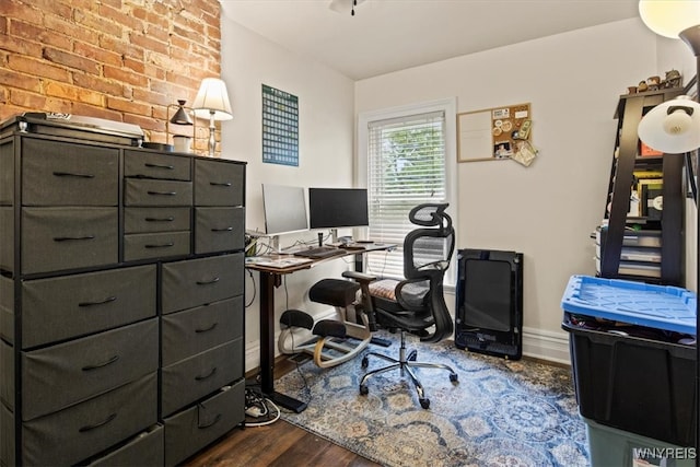 home office featuring brick wall and dark hardwood / wood-style floors