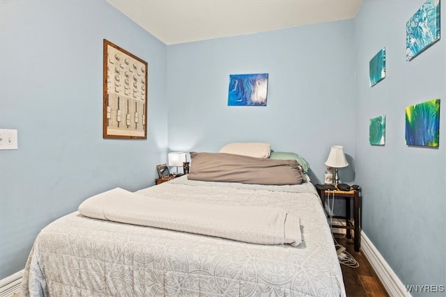 bedroom with dark hardwood / wood-style floors