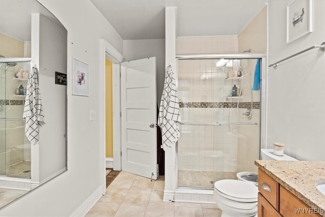 bathroom with vanity, tile patterned floors, a shower with shower door, and toilet