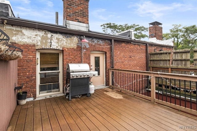 wooden terrace featuring a grill