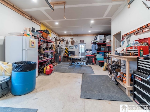 garage featuring a workshop area and white fridge