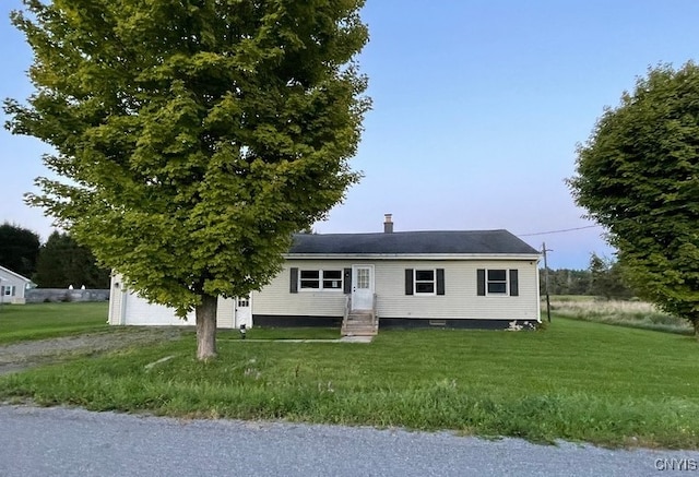 view of front of property with a front yard and a garage