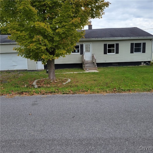 view of front of property with a garage and a front lawn