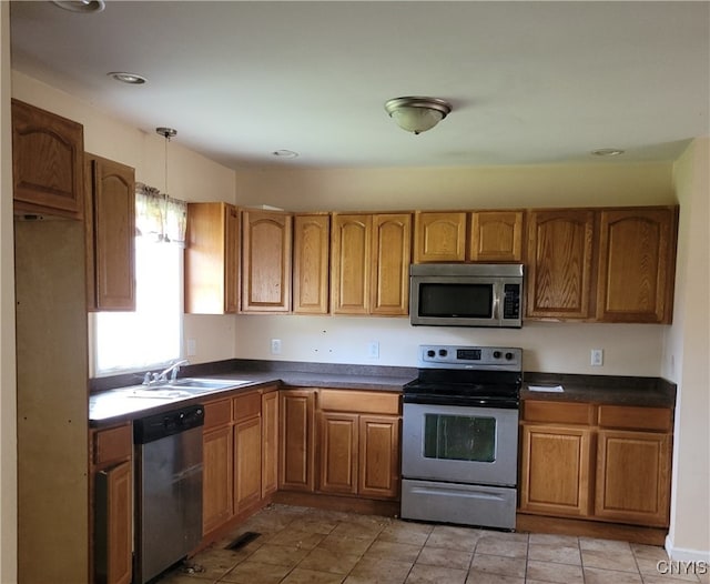 kitchen featuring pendant lighting, appliances with stainless steel finishes, sink, and light tile patterned flooring