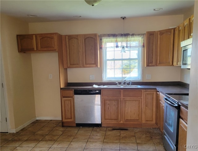 kitchen featuring light tile patterned floors, sink, decorative light fixtures, and appliances with stainless steel finishes