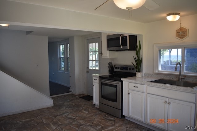 kitchen featuring ceiling fan, white cabinets, stainless steel appliances, and sink